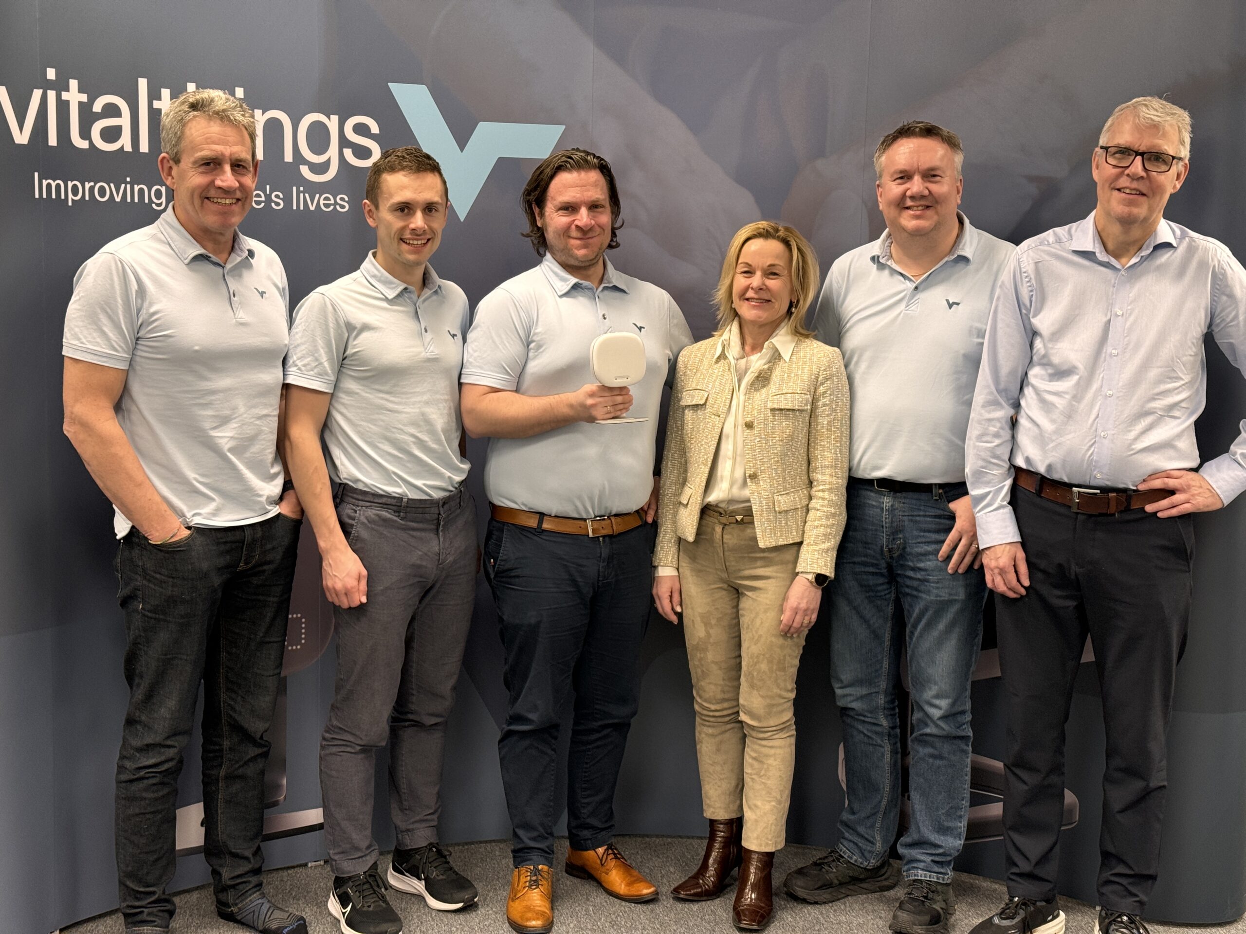 The Vitalthings team in front of the exhibition wall. Chief Medical Officer, Ole Kristian Thu, holding Guardian H10, together with founders Ole Johan Ellingsen, Bård Benum and Alf-Egil Bogen, Product Manager Trond Håkon Trondsen and Commercial Director Heidi Blengsli Aabel.
